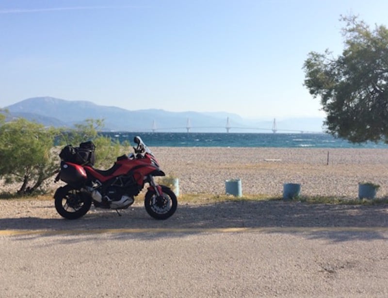 A red Ducati motorcycle by the beach
