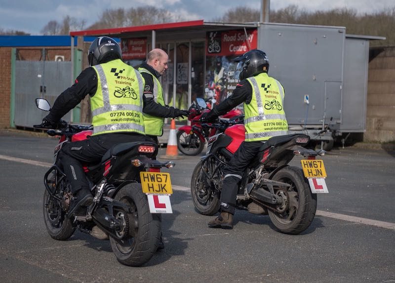Two learners getting instruction to pass their motorcycle test