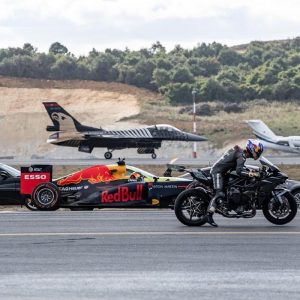 a motorcycle racing against a formula one car and a fighter jet