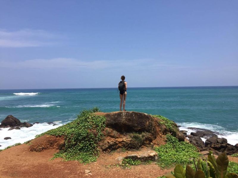 Motorcycle tour of Sri Lanka. Woman looking out to the Indian Ocean.