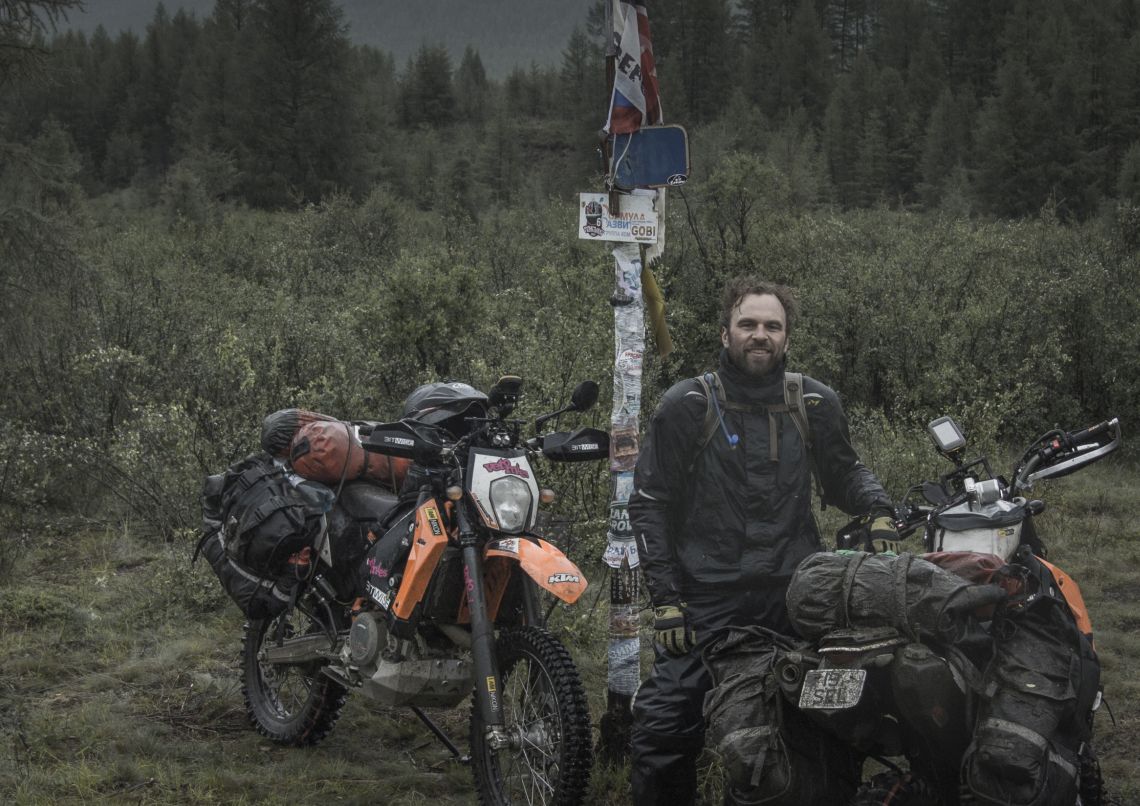 Jussi stood next to the 110 kilometre marker